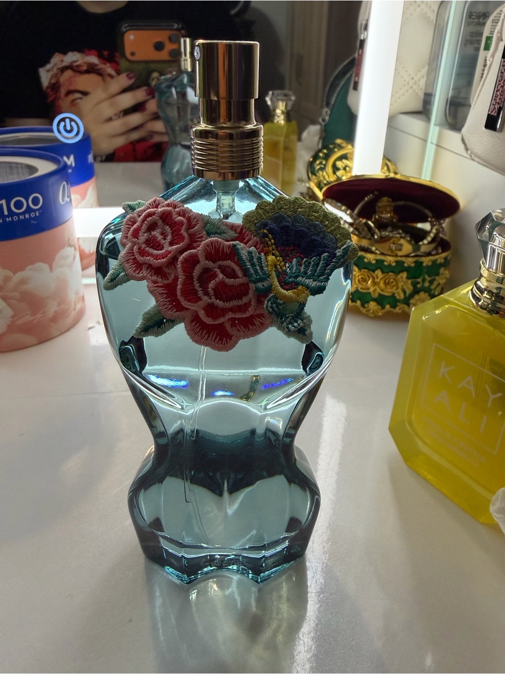 Jean Paul Gaultier blue bottle with embroidered pink floral patch